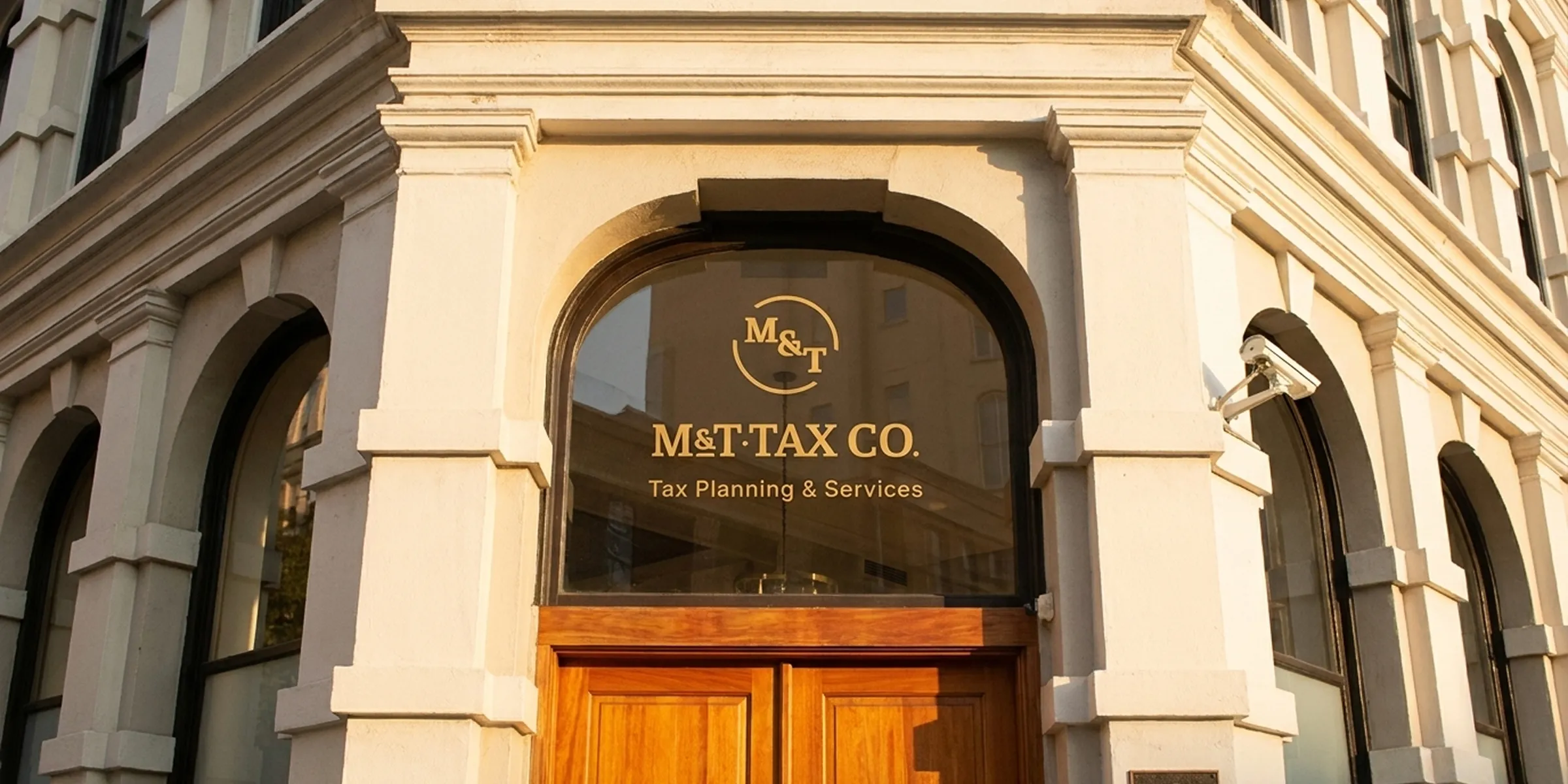 M&T Tax Co. storefront entrance with gold logo lettering on the glass door