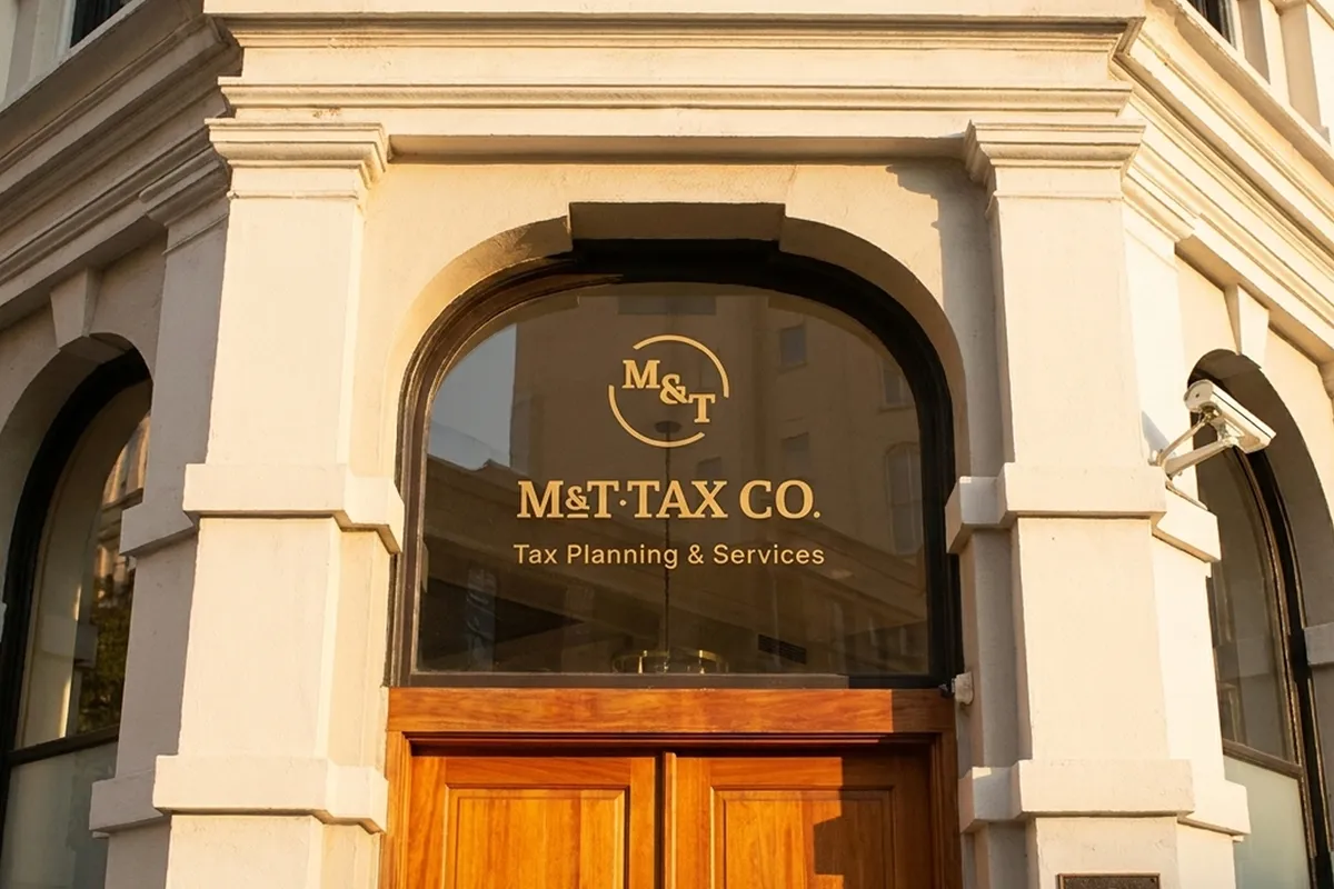 M&T Tax Co. storefront entrance with gold logo lettering on the glass door